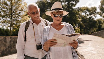 Pareja de adultos mayores observando un mapa mientras están de viaje