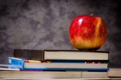 Libri e una mela sul tavolo: sta arrivando il ritorno a scuola scontato