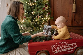 Madre le da un regalo a su bebé por navidad