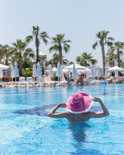 mujer en piscina de hotel