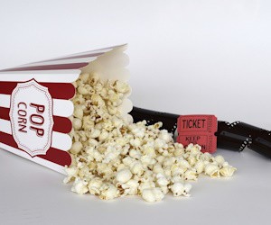 Palomitas sueltas con tickets del cine y el rollo de la película