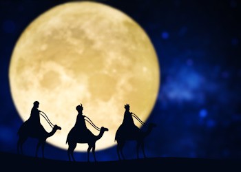 Silueta de los tres Reyes Magos por la noche con la luna de fondo