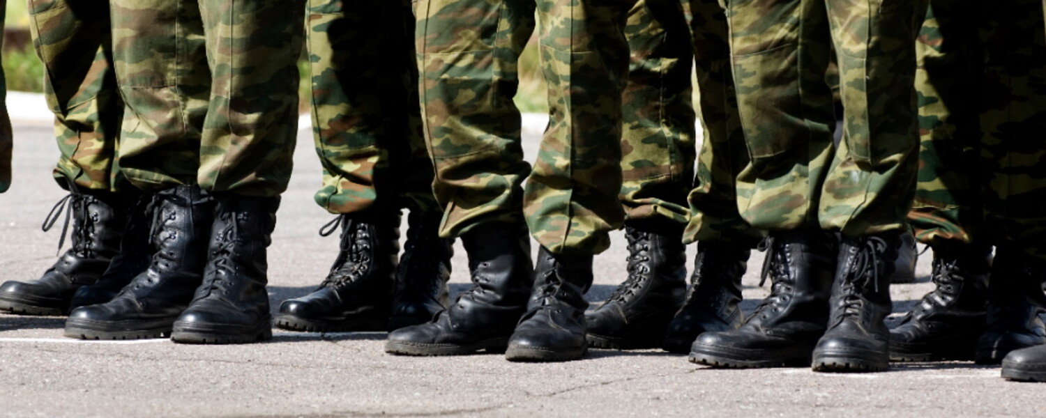 Pies de varios militares en fila con sus botas y pantalones de uniforme