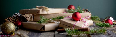 brown paper wrapped packages stacked together with some winter decorations