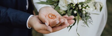 Manos de esposos enseñando las alianzas de boda