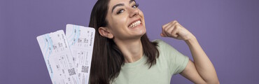 Chica feliz sujetando dos boletos de viaje
