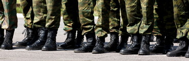 Pies de varios militares en fila con sus botas y pantalones de uniforme