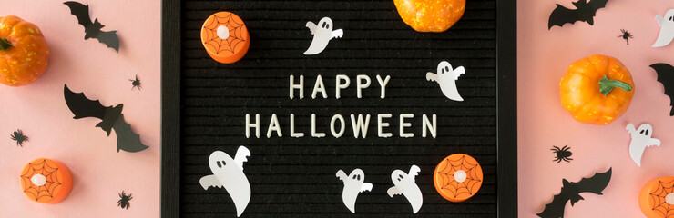 Fondo rosa claro con escrito "Happy Halloween" y decoración con calabazas, fantasmas, murciélagos y arañas.