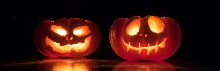 two jack-o-lanterns glowing in the dark