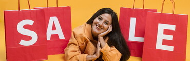 Imagen de chica con bolsas de compras que dice "Sale"