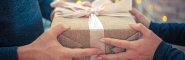 Manos de dos personas sujetando un regalo