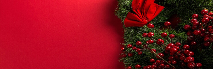 Ein weihnachtlich geschmückter Kranz mit Johannisbeeren und Schleife