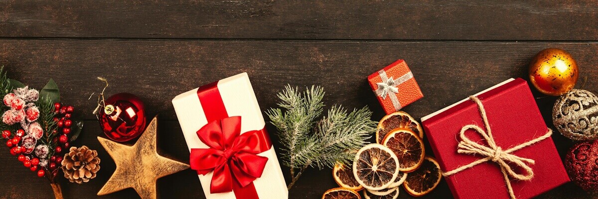 Regalos y decoración de navidad apoyados sobre una mesa de madera