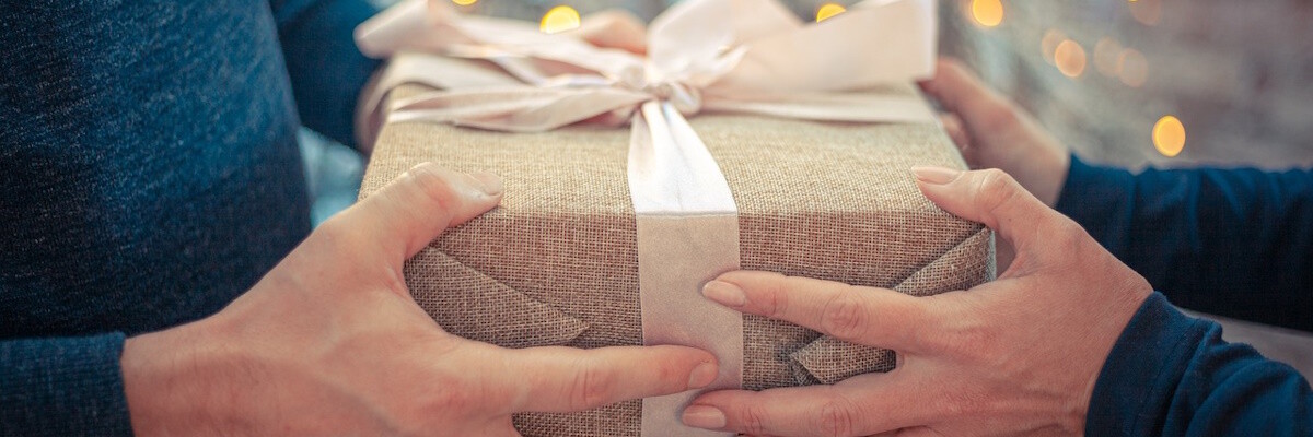 Manos de dos personas sujetando un regalo