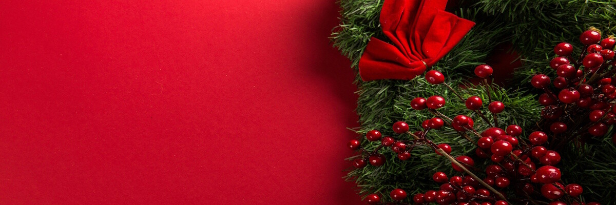 Ein weihnachtlich geschmückter Kranz mit Johannisbeeren und Schleife