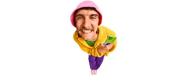 Glücklicher Mann in bunter Kleidung mit Smartphone