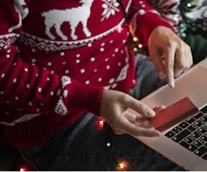 Hombre con jersey navideño haciendo compras online