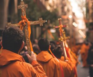 Procesión de personas vestidas de naranja con cruces
