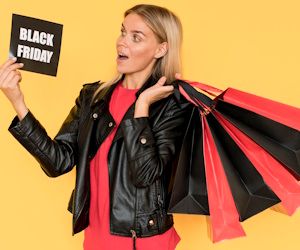 mujer rubia de pie con bolsas de compras y un letrero en la mano con la frase Black Friday