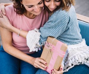 dos mujeres abrazadas intercambiando un regalo