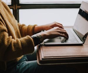 Ahorra en tecnología con las mejores ofertas de la temporada hombre sentado frente a una mesa mientras escribe en su laptop