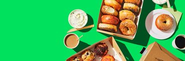 bagels and muffins in boxes with spreads and drinks