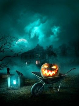 Una zucca di Halloween su una carriola, davanti ad una casa stregata