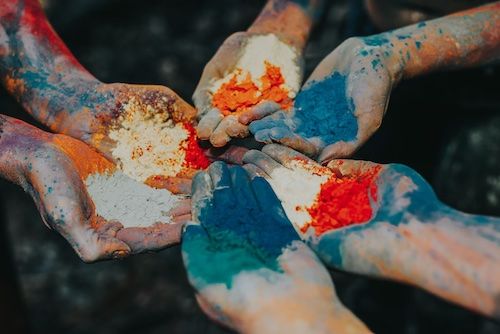 Hands full of colorful powder for celebrating Holi