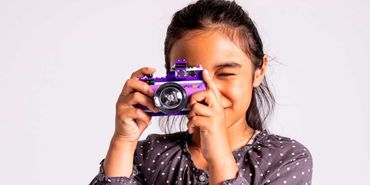 Une enfant qui prend une photo avec un LEGO