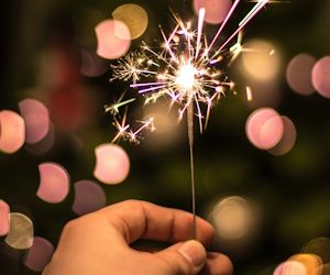 Prepárate para la Navidad con las ofertas que traemos para ti mano que sostiene una luz de bengala encendida