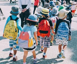 Compra los uniformes, mochilas y accesorios con un gran descuento grupo de niños que usan mochila y van caminando