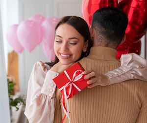 Pareja abrazada recibiendo sorpresa y regalos de san valentin
