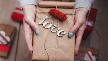 Entrega de paquete regalo con la escrita "Love" Los mejores regalos para San Valentín