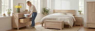 woman in a bedroom putting clothes in a chest of drawers