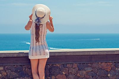Donna con cappello guarda il mare